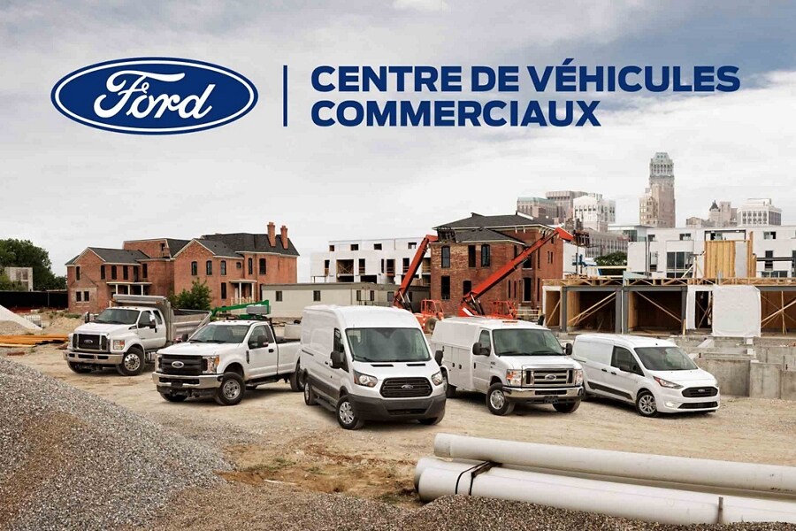 Une rangée de véhicules commerciaux avec un panneau d'affichage du centre des véhicules commerciaux Ford à l'arrière-plan