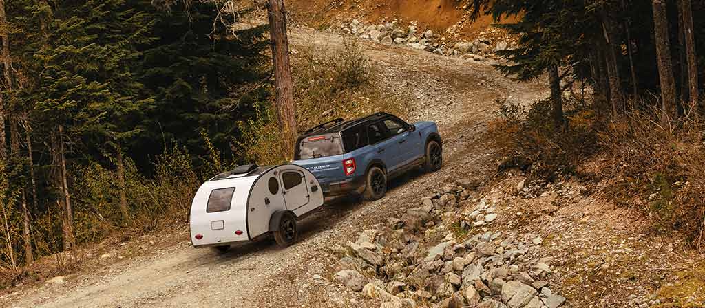 VUS Ford Bronco Sport® 2026 tirant une remorque sur une route de gravier de montagne