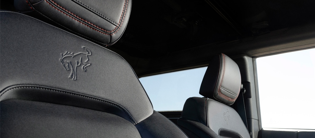 Gros plan de l'emblème en relief sur le revêtement des sièges avant d'un VUS Ford Bronco® Stroppe Edition 2025.