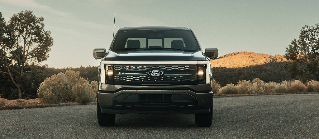 Une vue avant du Ford F-150® Lightning® 2025 stationné au coucher du soleil dans un endroit pittoresque