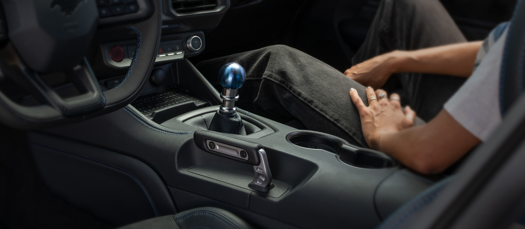 Une personne assise dans une Ford Mustang Dark Horse® Coupé 2026 avec un pommeau de levier de vitesses unique en titane bleu anodisé