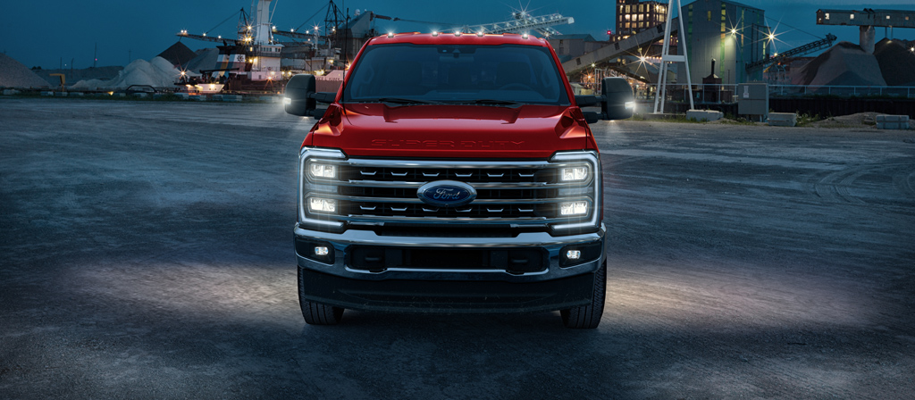 Camion Ford Super Duty® F-450® Lariat® 2026 avec ses lumières allumées stationné sur un chantier de construction au crépuscule