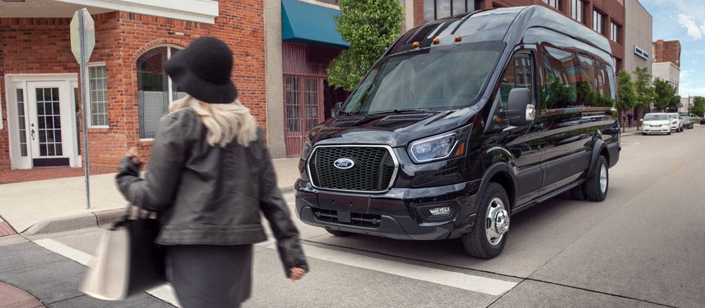 Deux personnes en camping et une fourgonnette Ford Transit® 2026 en arrière-plan