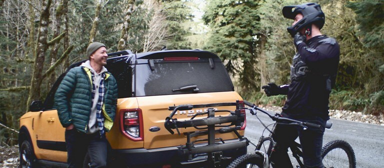 Deux hommes se tiennent debout à côté d'un Ford Bronco Sport jaune de 2021