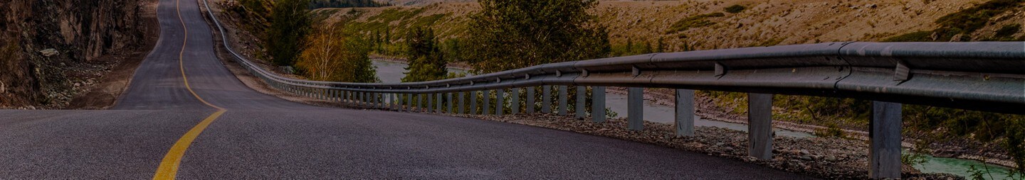 Une autoroute à deux voies serpente vers les montagnes au loin