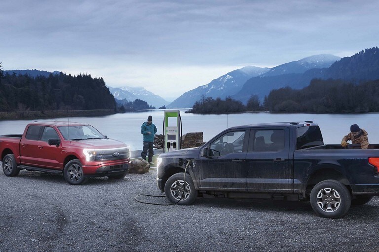 Deux camions F 150 Lightning en cours de recharge dans une station publique reculée