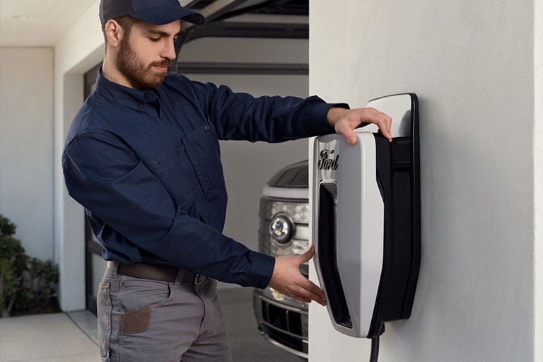Un technicien installe un chargeur V E dans un garage