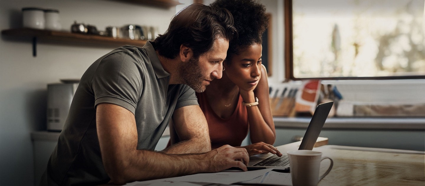Deux personnes utilisent un ordinateur portable. 