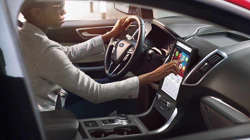 Une personne manipule l'écran tactile de 12 pouces d'un véhicule Ford