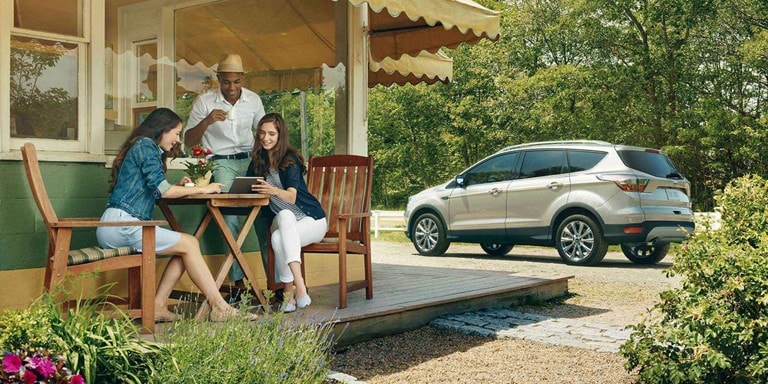 les gens autour d'une table avec un VUM Ford en arrière-plan