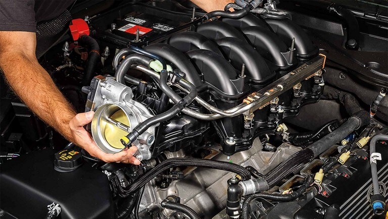 Un technicien Ford travaille sur un moteur