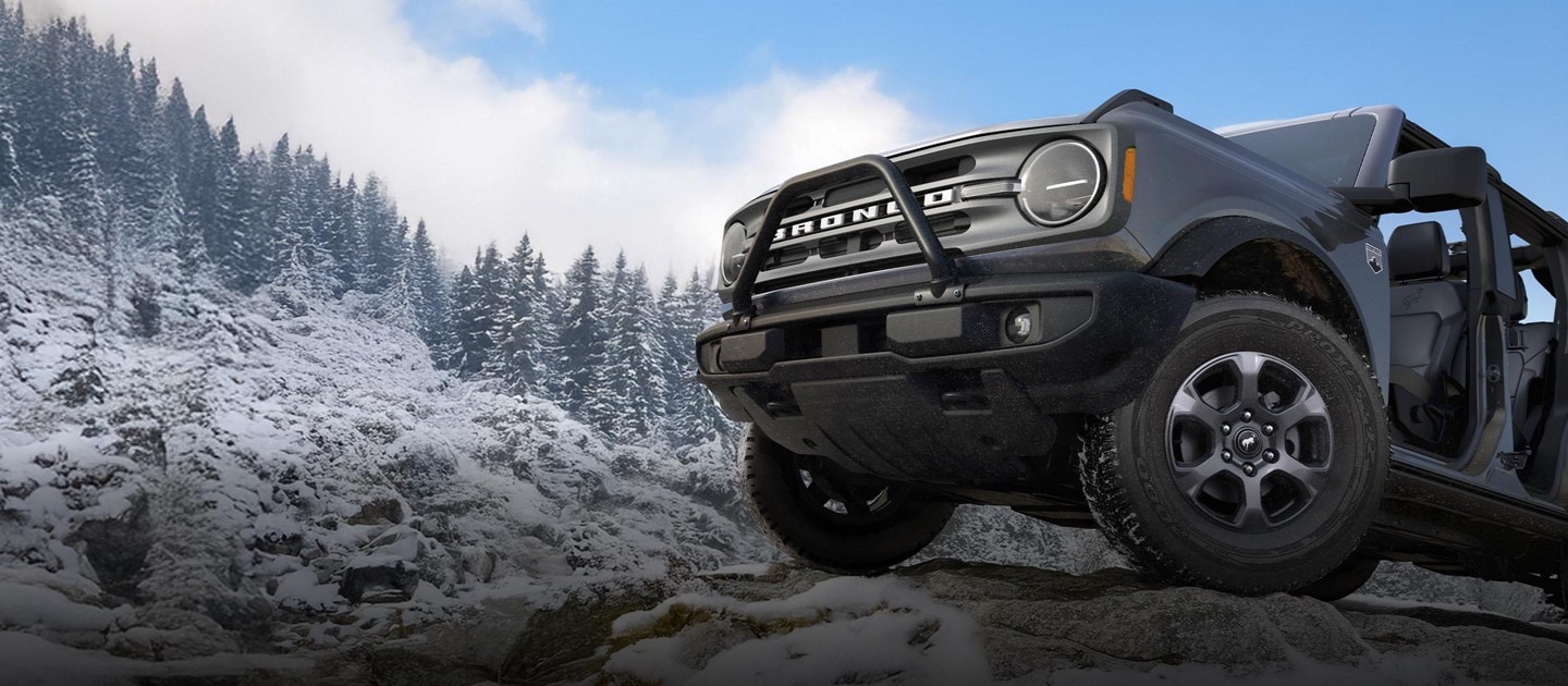 Un Bronco 2025, portes ouvertes, garé sur une montagne enneigée