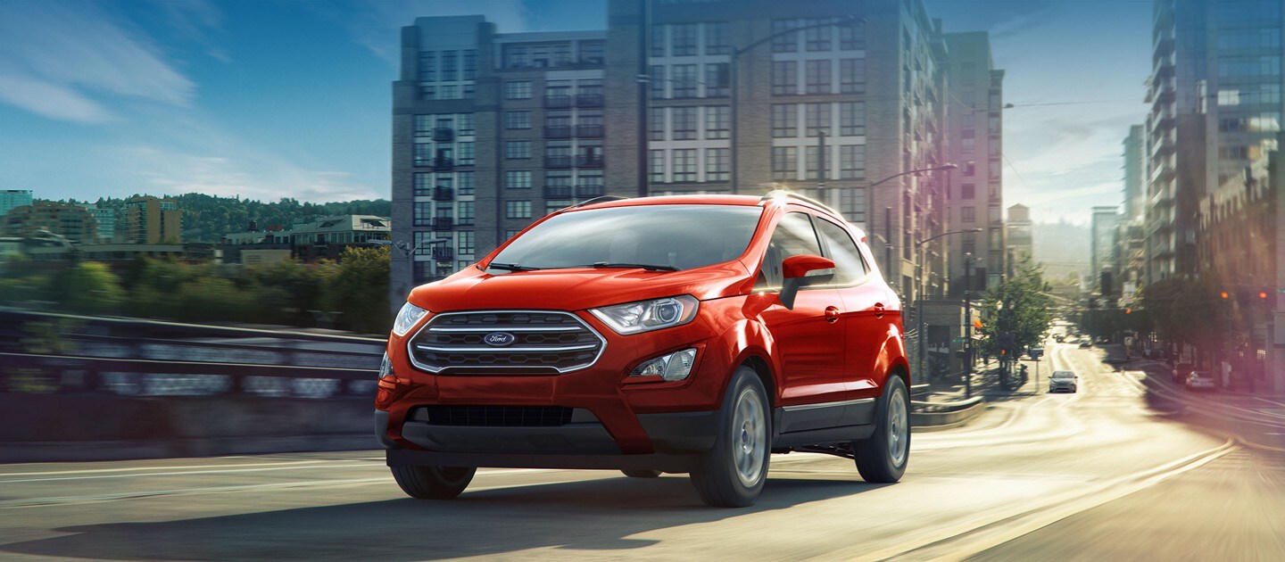 Un Ford EcoSport rouge circule dans une rue de la ville