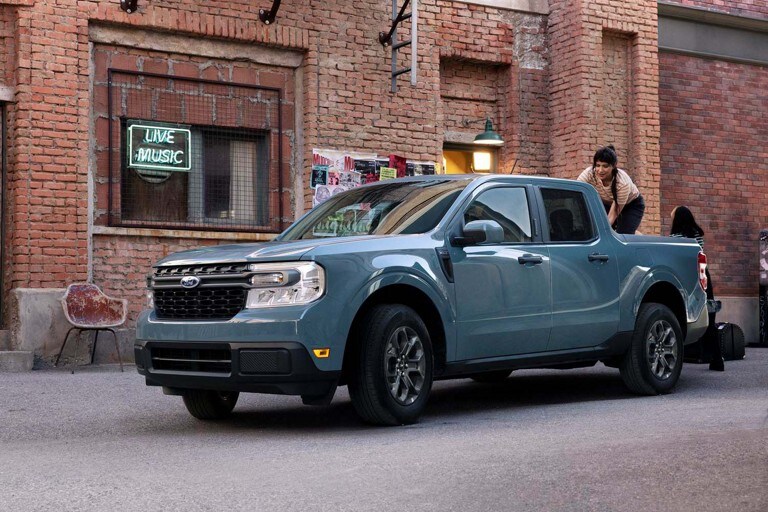 Un Ford Maverick bleu garé dans une rue urbaine