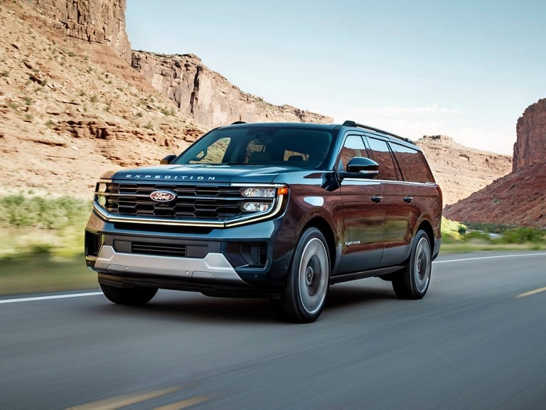 Modèle Ford Expedition® Platinum MAX 2025 circulant sur une route bordée de montagnes