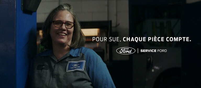 Une technicienne Ford souriante dans un garage