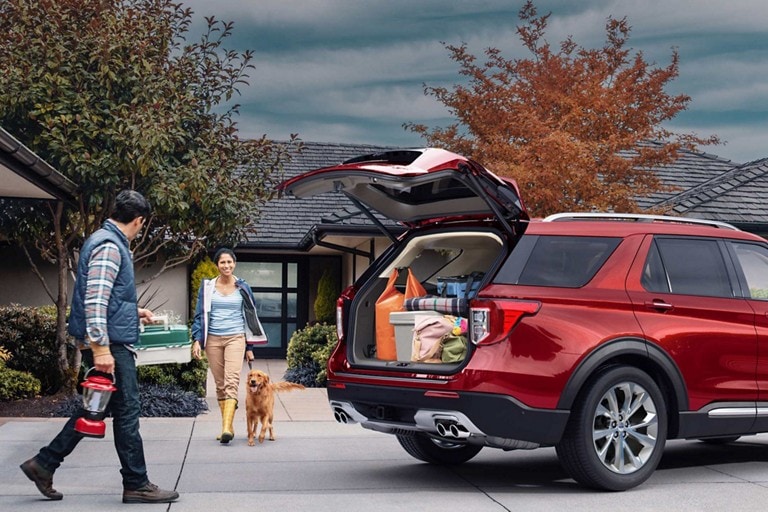 couple avec un chien marchant vers  un VUS Ford