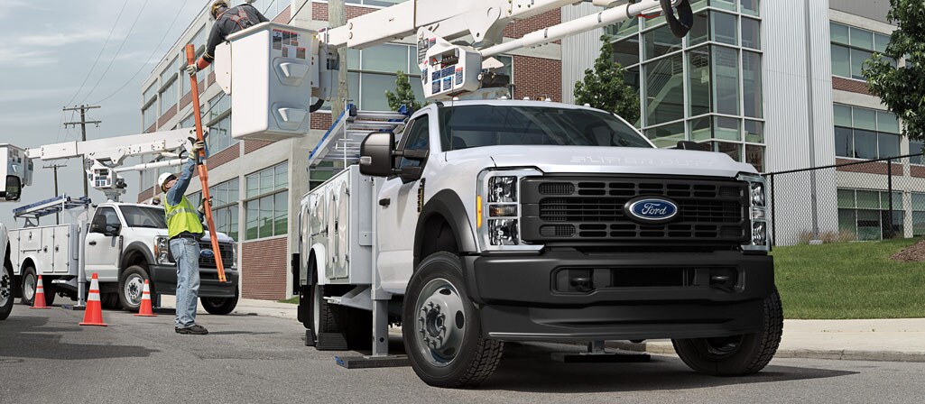 Deux travailleurs utilisant la rallonge de flèche sur un Ford Super Duty® à châssis-cabine 2026 pour réparer un poteau électrique