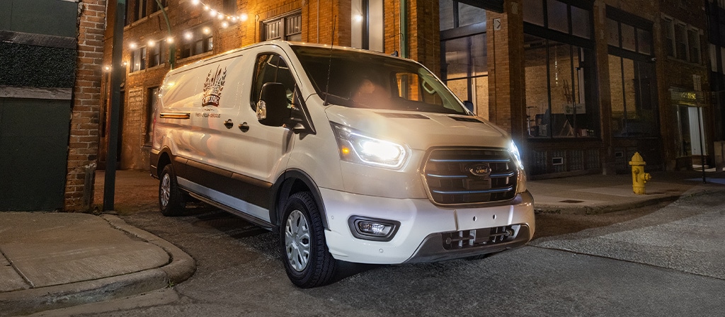 Une fourgonnette Ford E-Transit™ 2025 blanche reculant dans un point de livraison