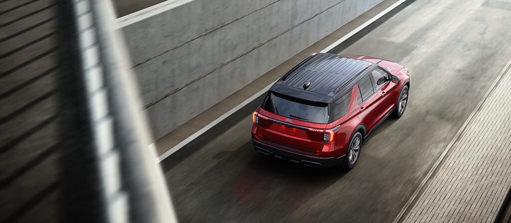 Ford Explorer® 2025 rouge circulant dans une rue de la ville
