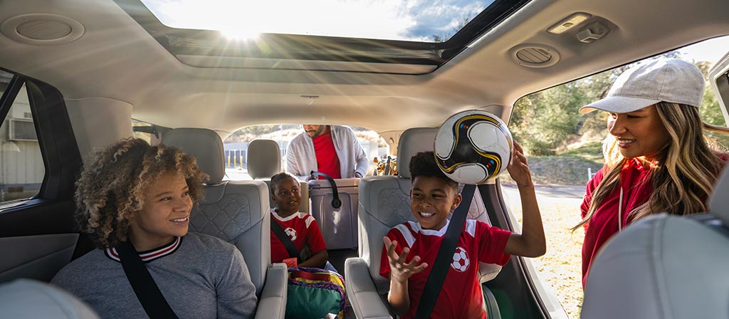 Intérieur du Ford Explorer® 2025 avec une famille assise à l’intérieur, montrant le toit panoramique Vista