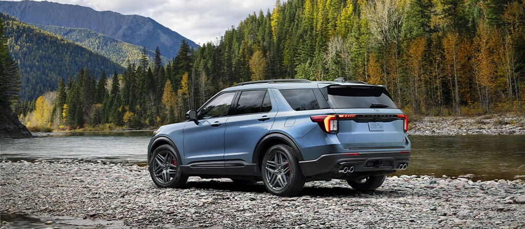 VUS Ford Explorer® 2025 bleu stationné sur des pierres près du lit d’une rivière
