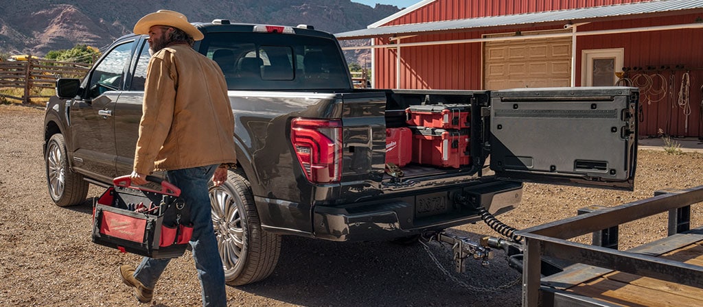 Une personne marchant près d’un camion Ford F-150® 2025 avec le hayon Pro Access ouvert