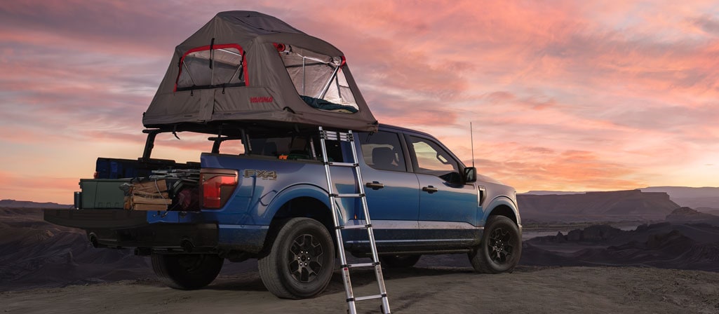 Camion Ford F-150® FX4® 2025 en bleu Atlas avec une tente de caisse accessoires pour camion Ford au crépuscule