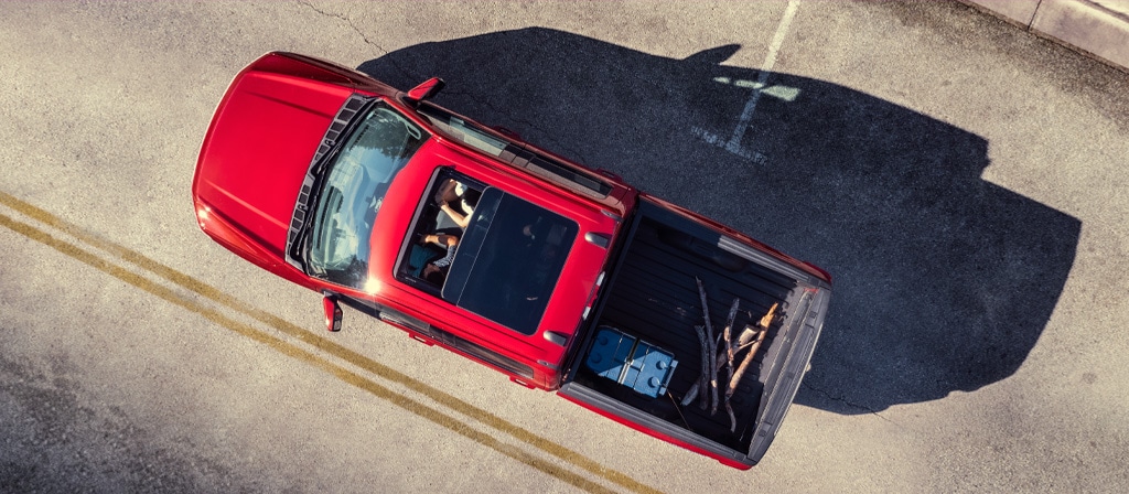 Une vue aérienne de deux personnes dans un Ford F-150® Lightning® 2025 avec toit ouvrant et chargement dans la caisse du camion