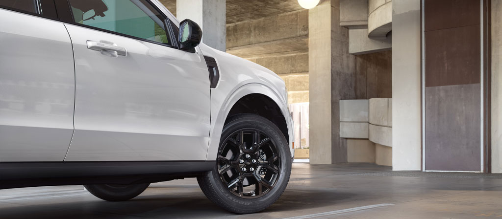 Une camionnette Ford Maverick® 2025 stationnée devant une structure en béton moderne
