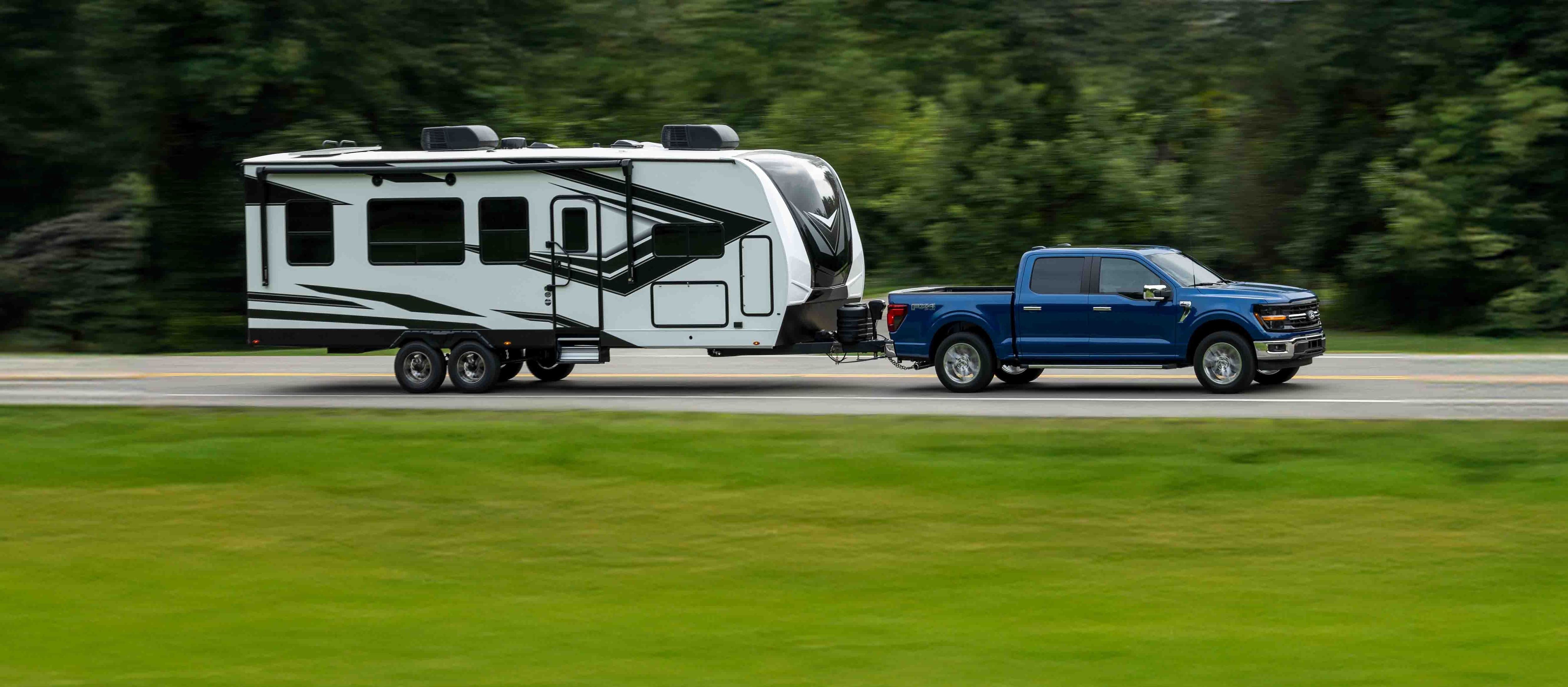 Un F-150 tractant une remorque sur une autoroute.