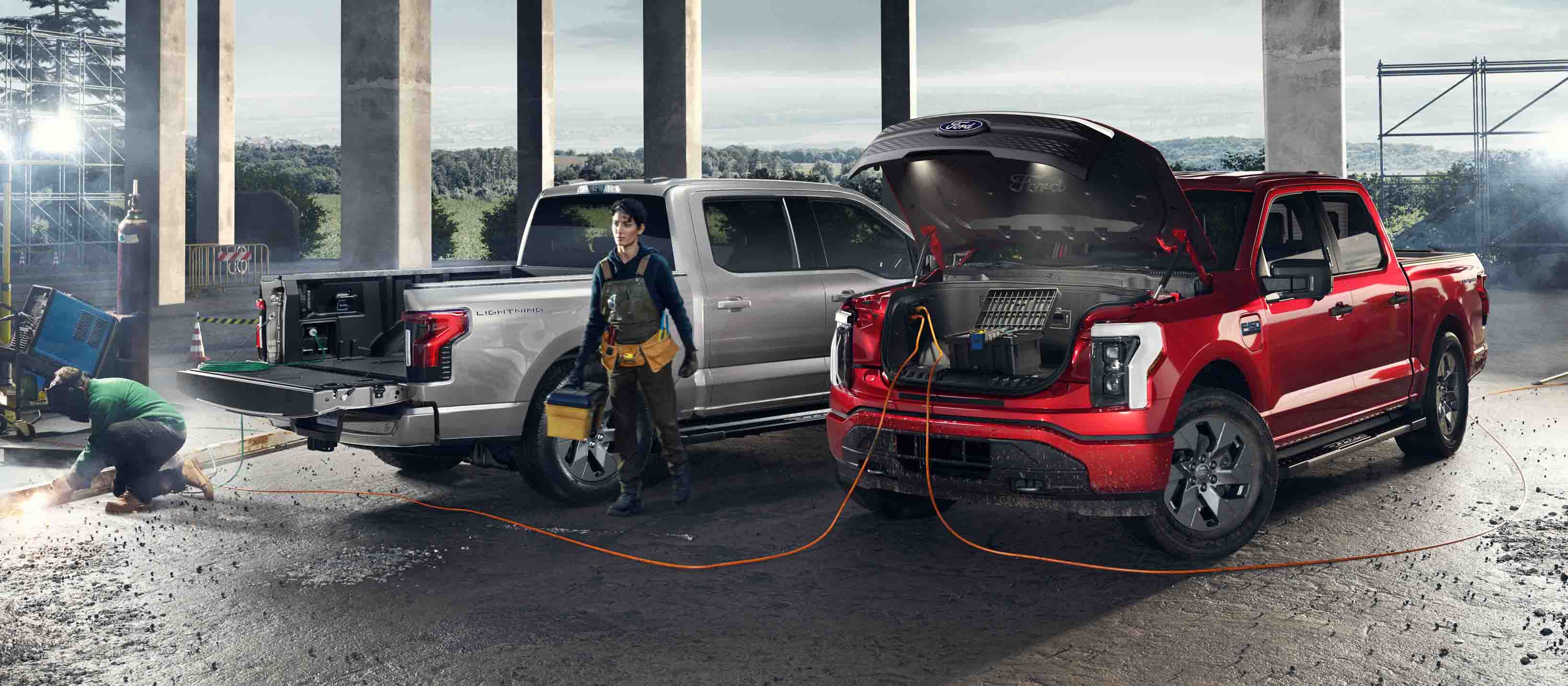 Deux camions F-150 Lightning stationnés sur un chantier avec des outils électriques et des équipements branchés dessus.