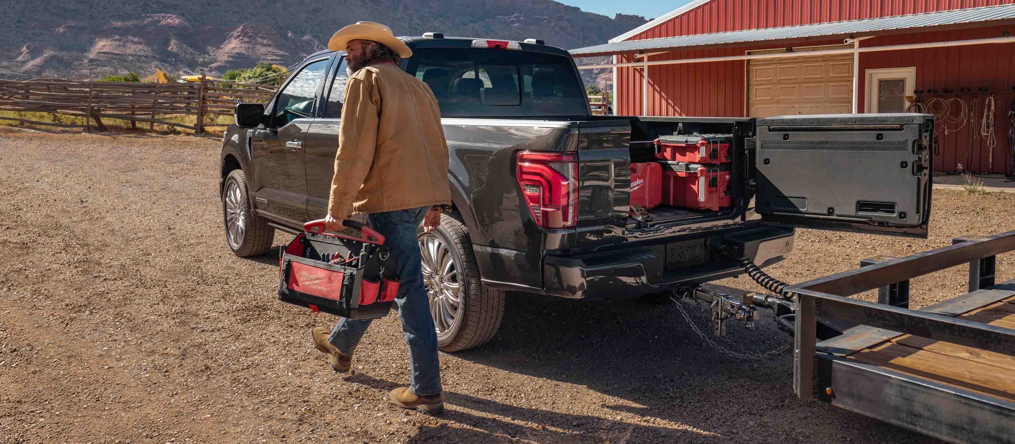 Un homme passe devant un F-150 avec une remorque attelée et le hayon Pro Access ouvert.