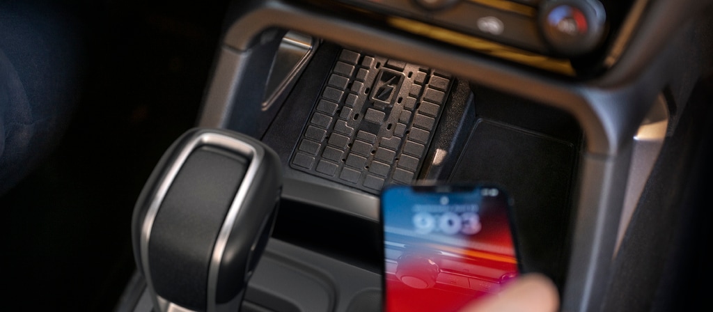 Gros plan d’une personne plaçant un téléphone sur le chargeur sans fil du Ford Ranger® 2025