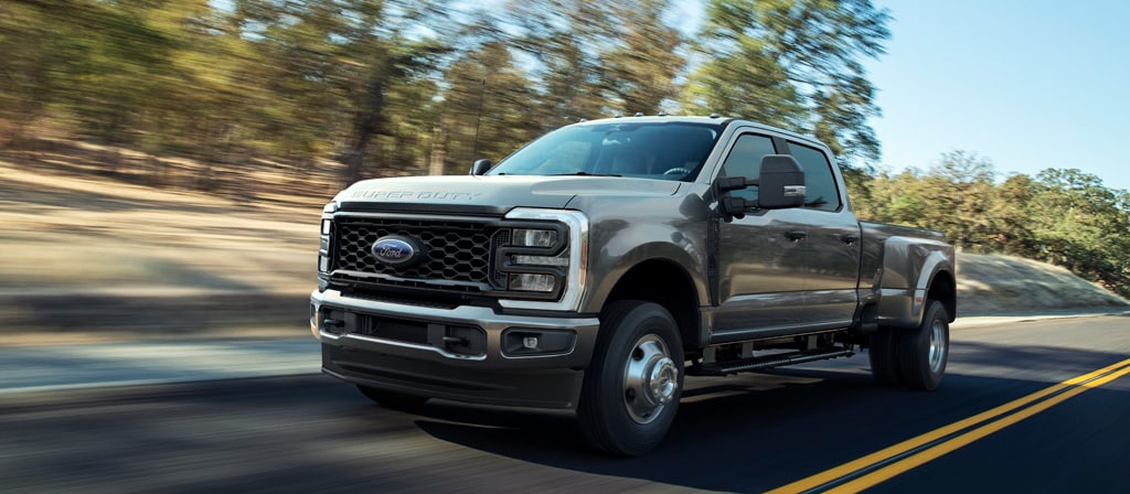 Ford Super Duty® F-250® XL 2026 avec ensemble décor STX® en gris carbonisé circulant sur une route pavée