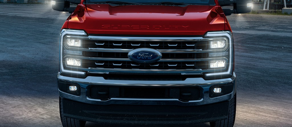 Un Ford Super Duty® 2026 sur un chantier la nuit avec ses phares allumés.