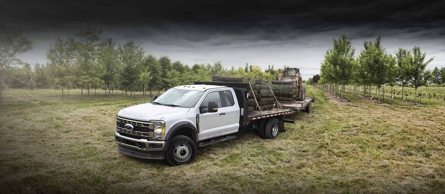 Un Ford Super Duty® F-450 XLT 2025 tirant solidement et remorquant un Bobcat