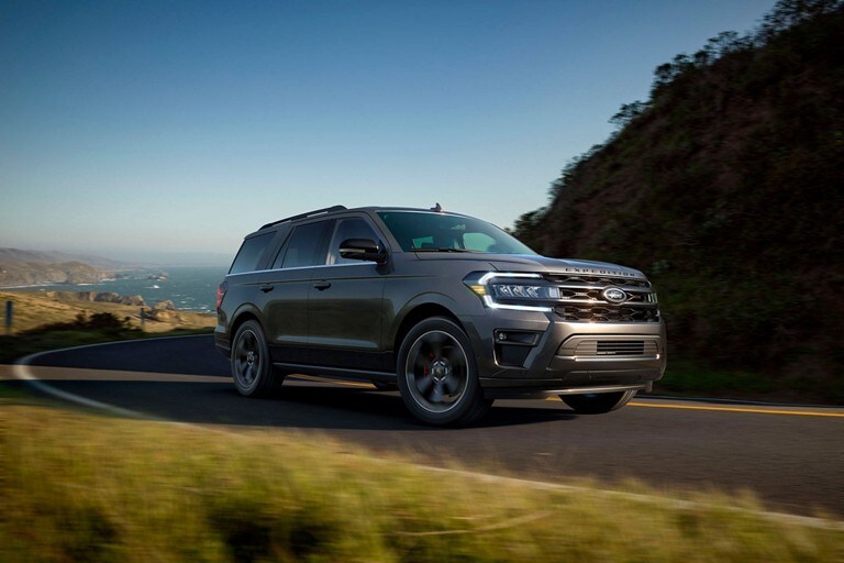 Un Ford Expedition 2023 sur une route sinueuse avec l’océan derrière