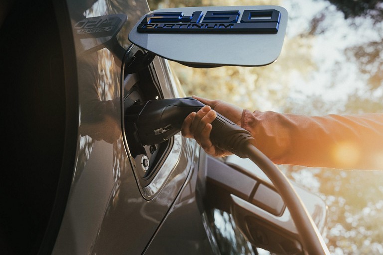 Une personne branche un câble de recharge sur un F 150 Lightning.