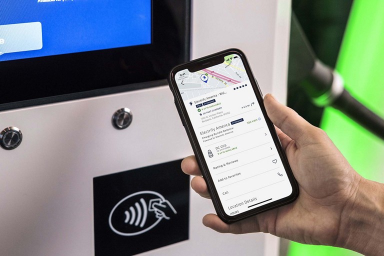 Une personne utilise l’appli FordPass sur son téléphone intelligent dans une station de recharge publique