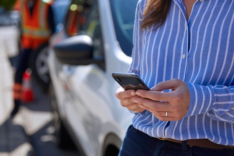 Une femme utilise un téléphone portable pour l'assistance routière