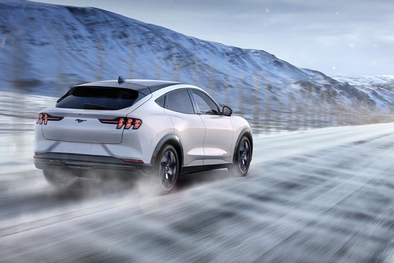 Une Ford Mustang Mach E roule sur une autoroute hivernale