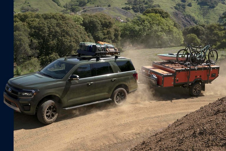 Un Ford Expedition tirant une remorque avec des vélos et un canoë montés.