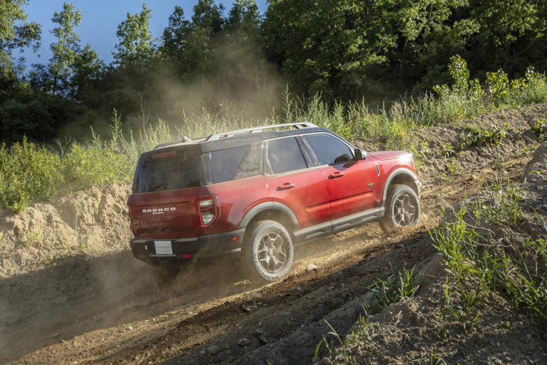 Un Ford Bronco Sport rouge en haut d'une colline sablonneuse