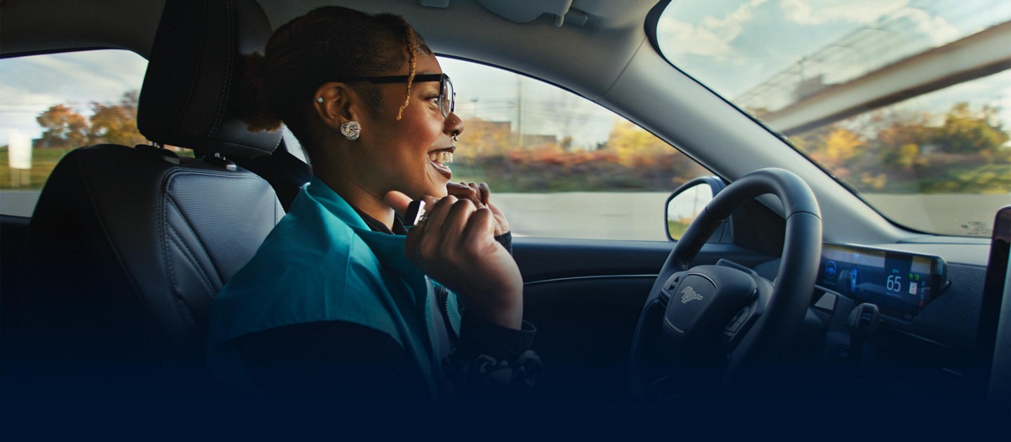 Une personne conduit un véhicule Ford sans les mains sur une autoroute.