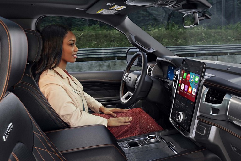 Une femme conduit un véhicule Ford en mode mains libres