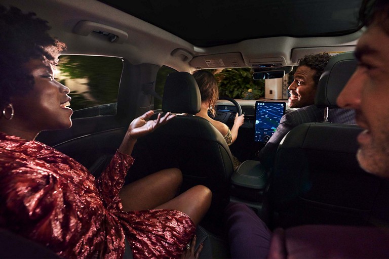 Trois passagers discutent gaiement dans un véhicule Ford.