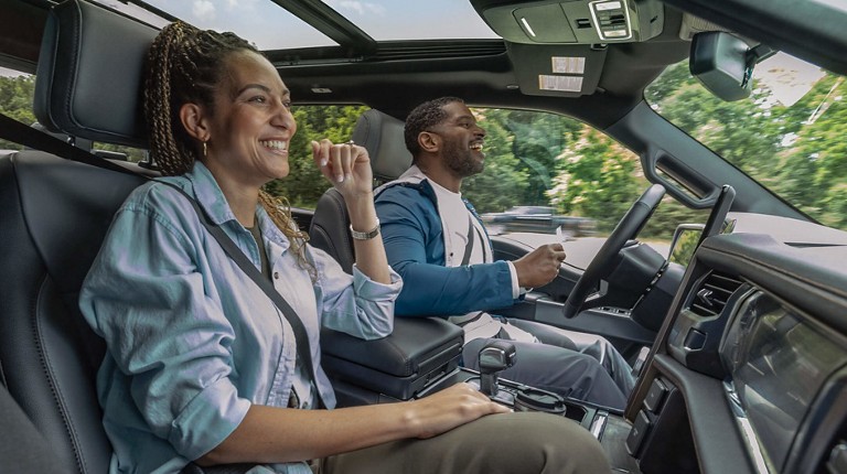 Un couple rigole ensemble alors que leur véhicule roule en mode mains libres.