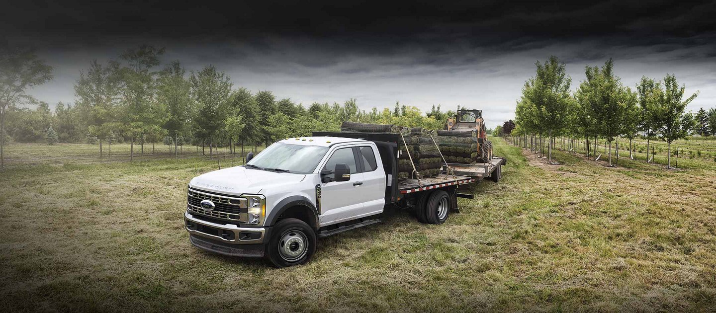 Un Ford Super Duty® F-450 XLT 2025 tirant solidement et remorquant un Bobcat