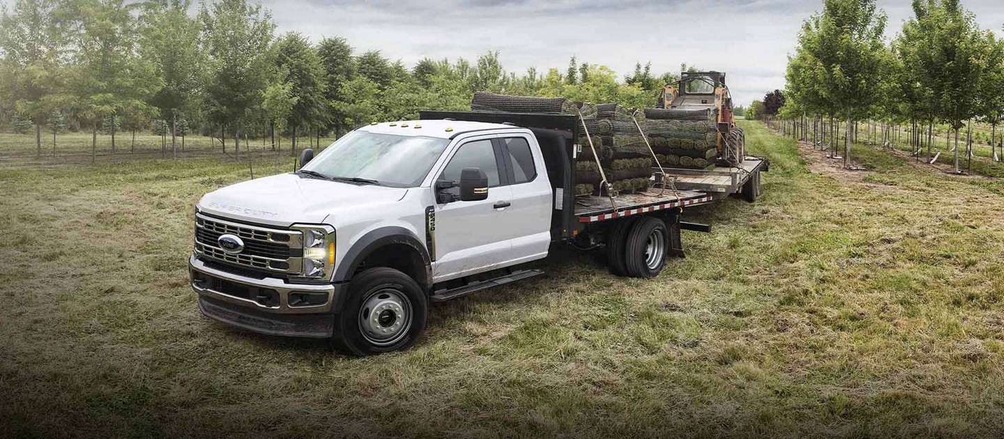 Un Ford Super Duty® F-350 2025 transportant de la tourbe et tirant une remorque avec un Bobcat